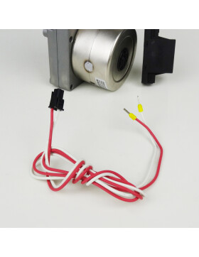 Das Bild zeigt einen Schneckenmotor für Pelletöfen mit einem zusätzlichen Anschlusskabel. Der Motor hat ein Metallgehäuse mit einem runden Lüftungsbereich auf der Rückseite. Im Vordergrund befindet sich ein rot-weißes Anschlusskabel mit einem schwarzen Stecker auf der einen Seite und zwei offenen Enden mit gelben Aderendhülsen auf der anderen. Das Bild enthält ein Wasserzeichen von „sos-ersatzteile.de“. Der Schneckenmotor wird verwendet, um die Förderschnecke eines Pelletofens anzutreiben und so die Pellets zur Brennkammer zu transportieren.