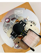 Unterseite eines MCZ-Abgasgebläses mit sichtbarem Motor und elektrischen Anschlüssen. Der Motor verfügt über eine schwarze Kunststoffabdeckung und eine kupferfarbene Wicklung. Die silberne Metallhalterung ist mit Schrauben befestigt, und im Hintergrund ist das Lüfterrad des Gebläses erkennbar. Ein Etikett mit technischen Angaben ist auf dem Gehäuse angebracht.