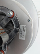 Unterseite eines MCZ-Abgasgebläses mit sichtbarem Motor und elektrischen Anschlüssen. Der Motor verfügt über eine schwarze Kunststoffabdeckung und eine kupferfarbene Wicklung. Die silberne Metallhalterung ist mit Schrauben befestigt, und im Hintergrund ist das Lüfterrad des Gebläses erkennbar. Ein Etikett mit technischen Angaben ist auf dem Gehäuse angebracht.